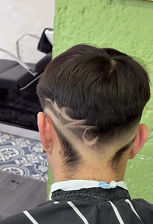 Nuca con fade y líneas de diseño marcadas a navaja, vista de espaldas.